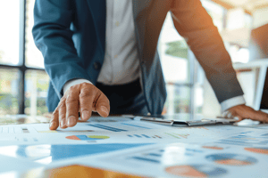 Business professional reviewing printed charts and performance data during a strategic planning discussion.
