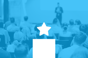 Audience attending a professional presentation, representing featured insights or discovery content