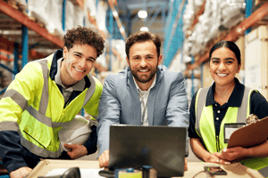 Warehouse team reviewing supply chain data on a laptop to support logistics planning and operational performance